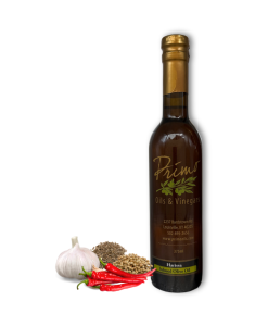 A 375ml bottle of Harissa Olive Oil with chili peppers, garlic and spices.