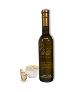 A 375ml bottle of Toasted Sesame Olive Oil with sesame seeds in a bowl and wooden scoop.