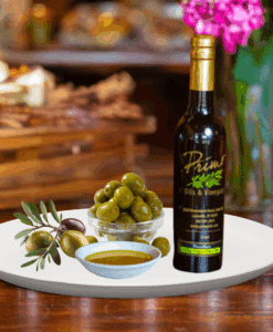 A 200ml bottle of Cobrancosa Olive Oil on white plate with bowl of olives from Portugal and sample olive oil