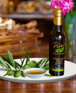A 200ml bottle of Manzanillo Extra Virgin Olive Oil on white plate with green olives grown from Australia and sample olive oil