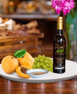 A 200ml bottle of Blenheim Apricot Balsamic on white plate with apricot and sample balsamic vinegar