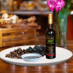 A 200ml bottle of Espresso Balsamic on white plate with dark roasted coffee and sample balsamic vinegar