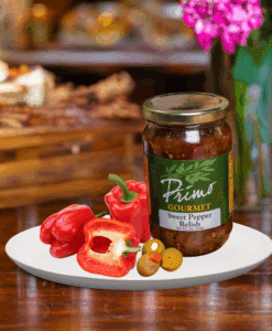 A jar of Sweet Pepper Relish on white plate with red pepper and olives
