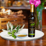 A 200ml bottle of Chiquitita Extra Virgin Olive Oil on white plate with olives from Portugal and sample olive oil