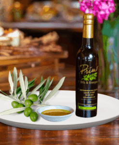 A 200ml bottle of Chiquitita Extra Virgin Olive Oil on white plate with olives from Portugal and sample olive oil