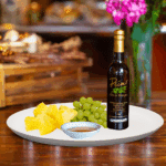 A 200ml bottle of Pineapple White Balsamic on white plate with pineapple slices and sample balsamic vinegar