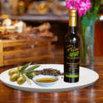 A 200ml bottle of Madagascar Black Pepper on white plate with black peppercorn and sample olive oil