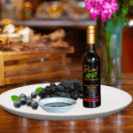 A 200ml bottle of Blueberry Balsamic on white plate with blueberries and sample balsamic vinegar