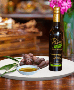 200ml bottle of Arbequina Olive Oil on white plate with olives grown in Chile and sample of olive oil