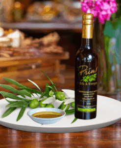 A 200ml bottle of Lentrisca Olive Oil on white plate with green olives grown in Portugal and sample olive oil